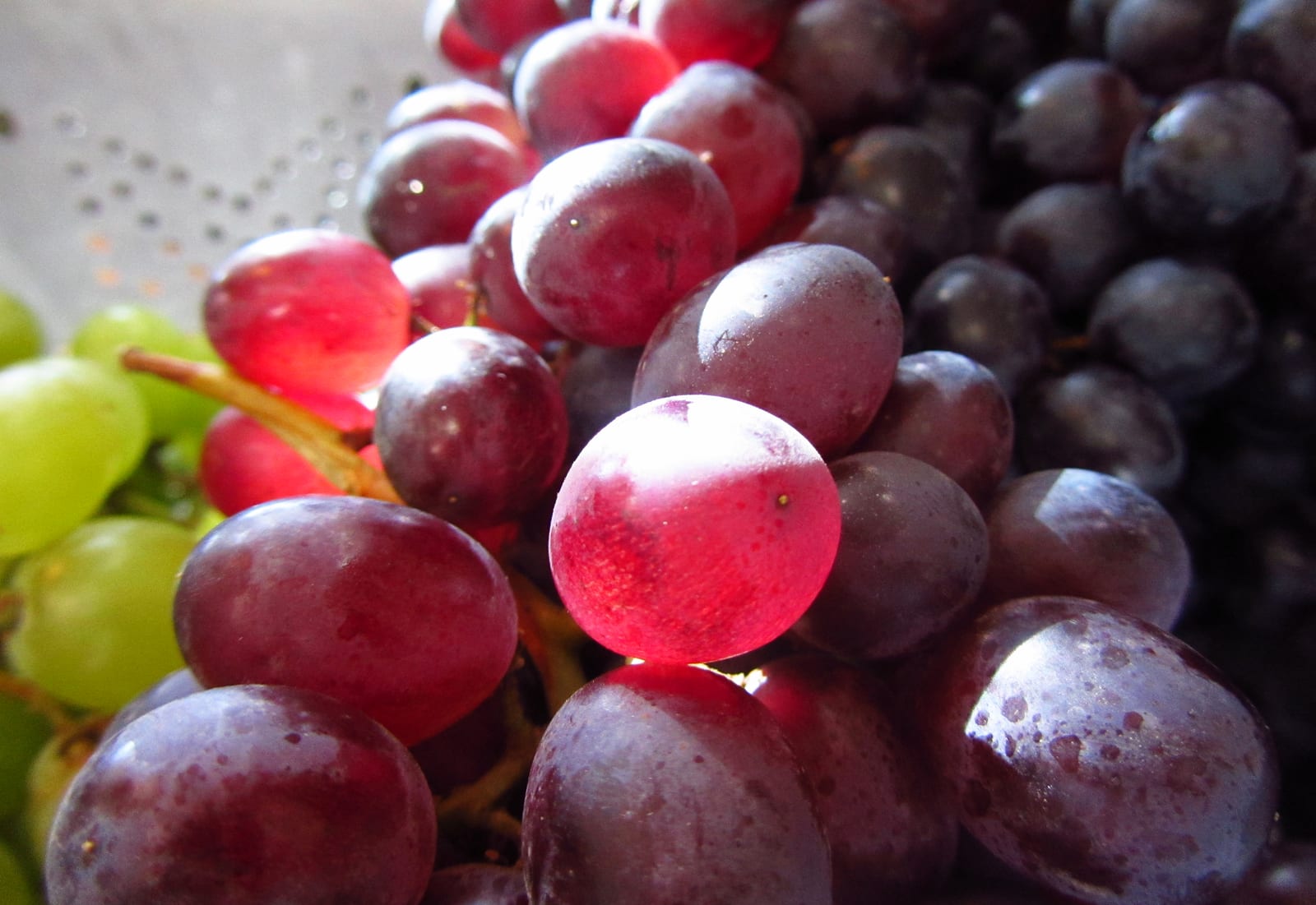 Clusters of red and green table grapes piled together.