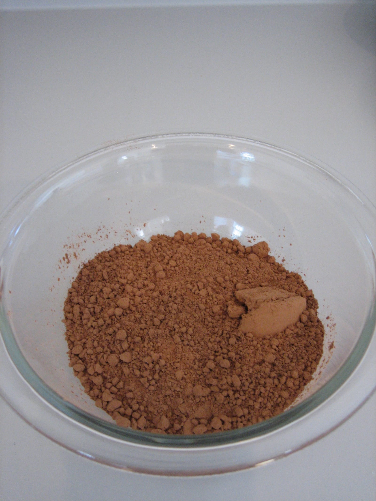 Unsweetened cocoa powder in a clear glass bowl.