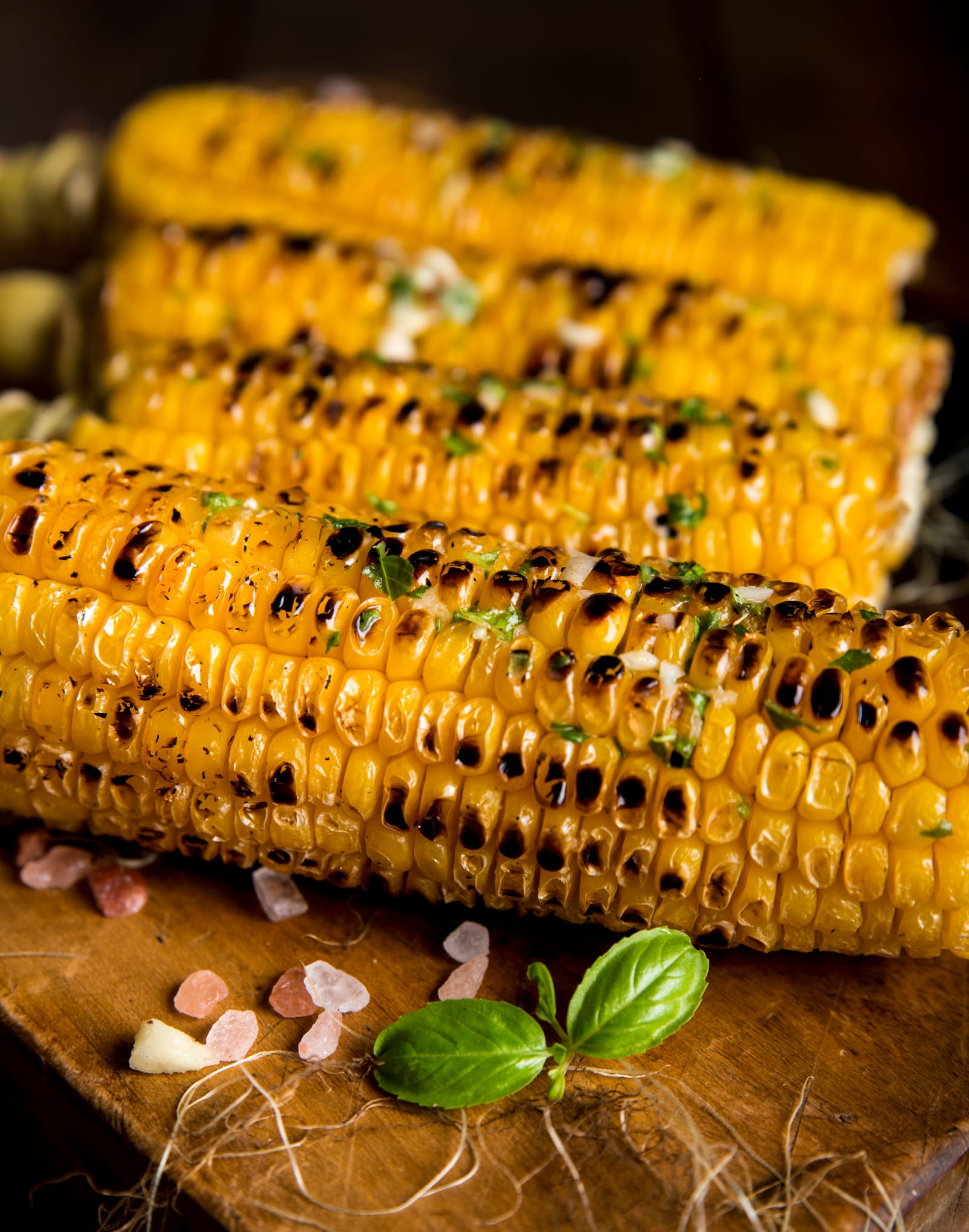 Close view of yellow corn kernels marked with dark blisters from the grill.