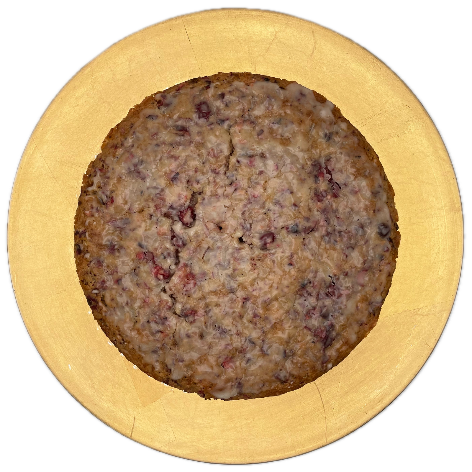 A round cranberry bread with a thin pale glaze centered on a gold plate.