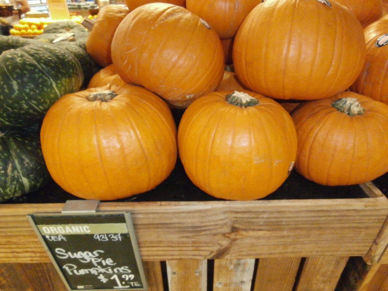 A market bin filled with sugar pie pumpkins.