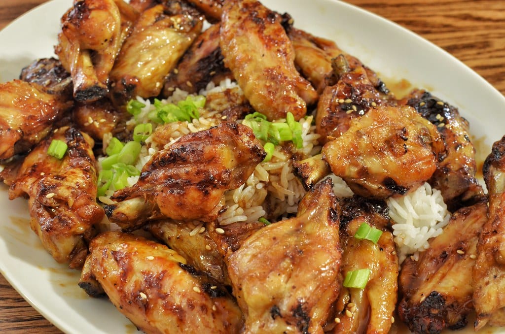 A platter of deeply browned honey-glazed chicken pieces.
