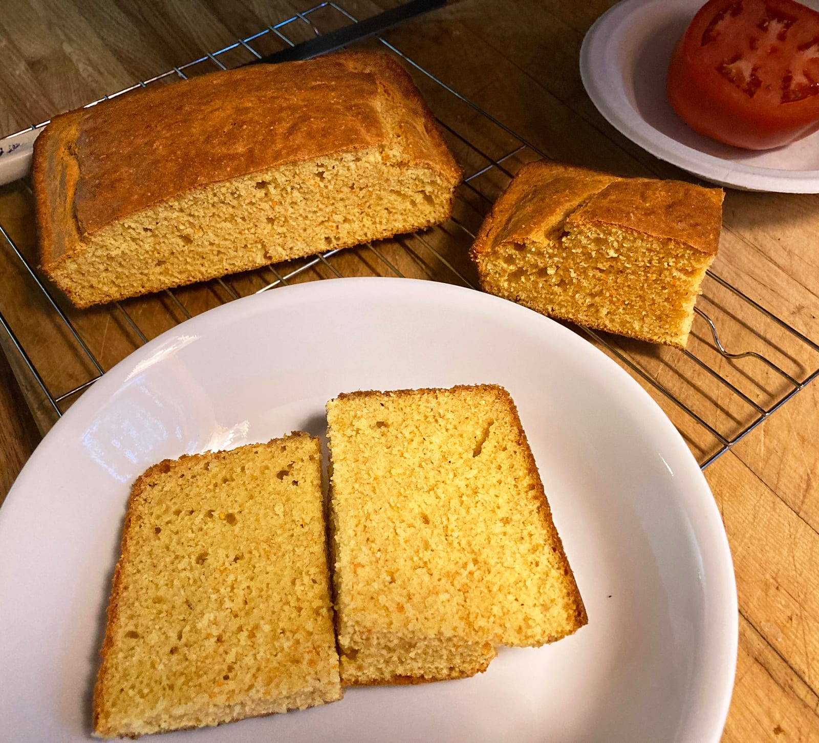 Golden Southern-style cornbread cut into thick square pieces beside a cooling rack.
