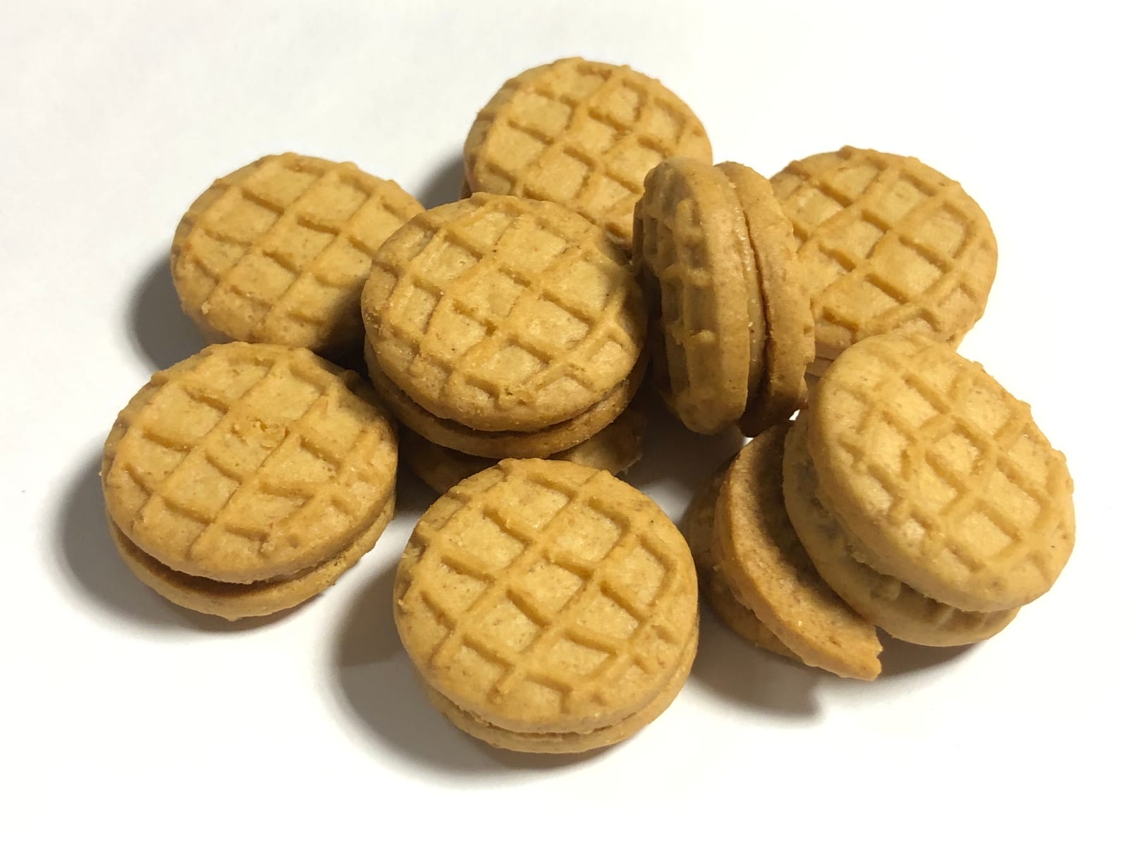 Small round Nutter Butter Bites sandwich cookies piled on a white plate.