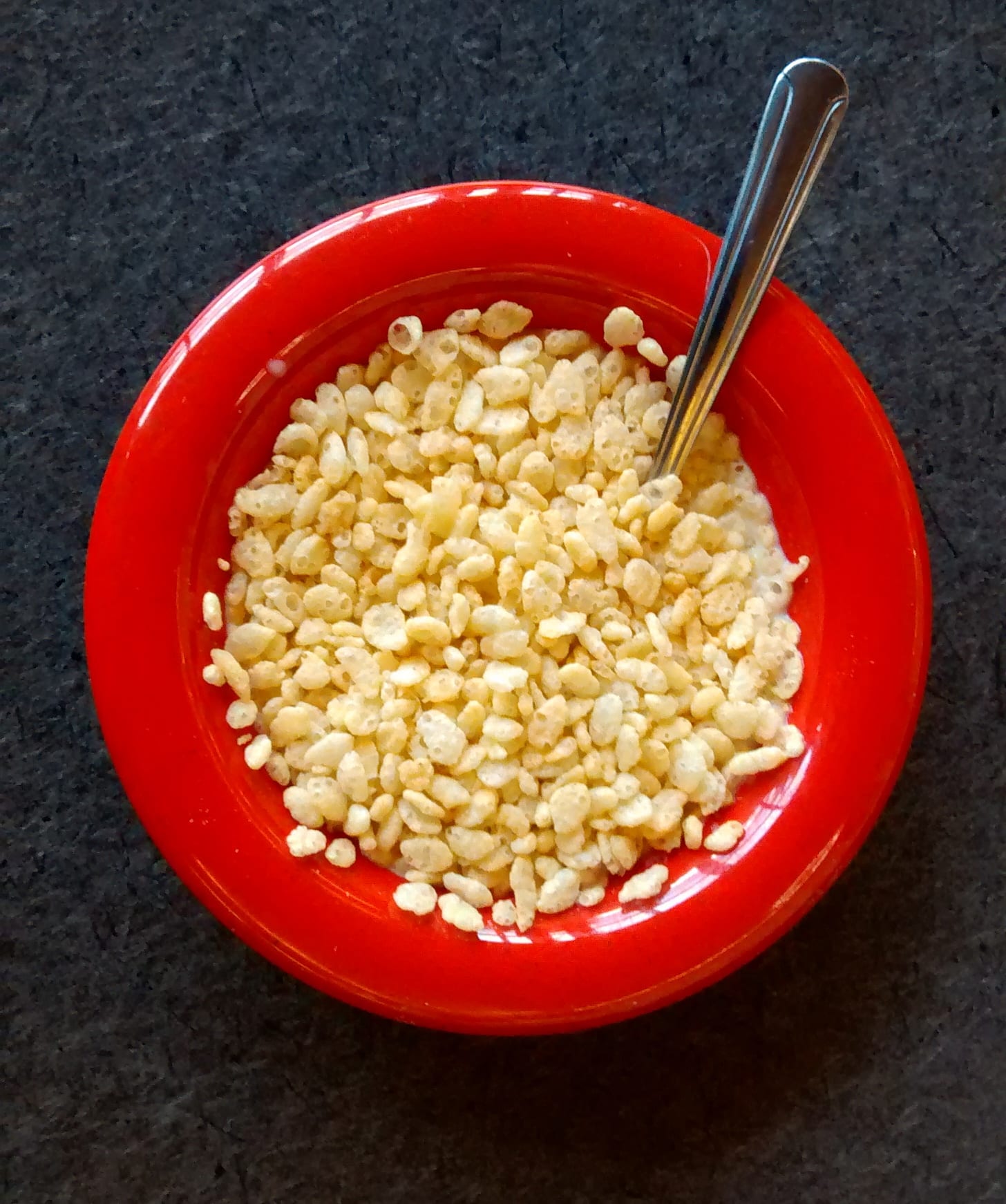 Puffed rice cereal in a bright red bowl.