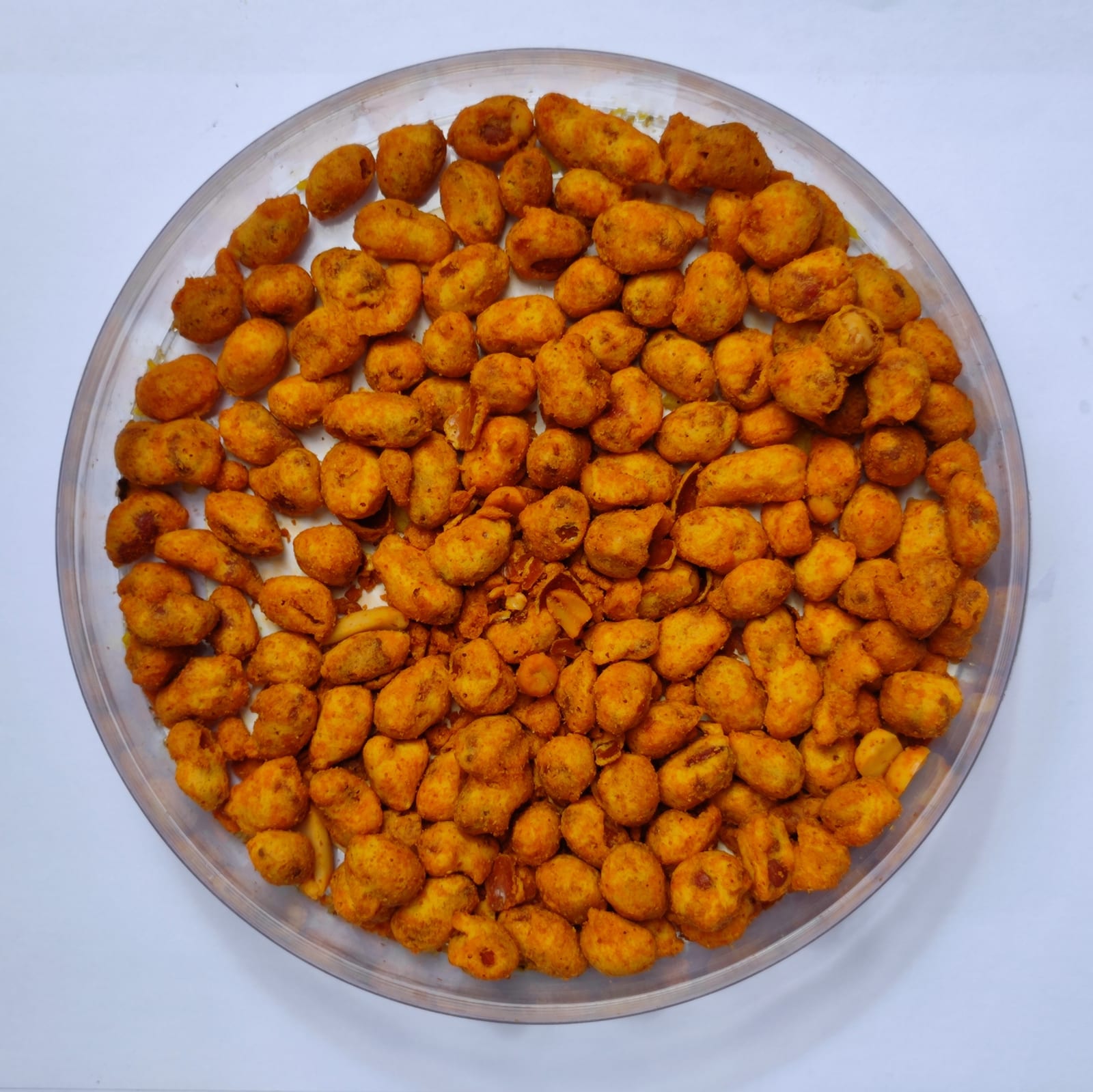 A glass bowl filled edge to edge with golden roasted peanuts.