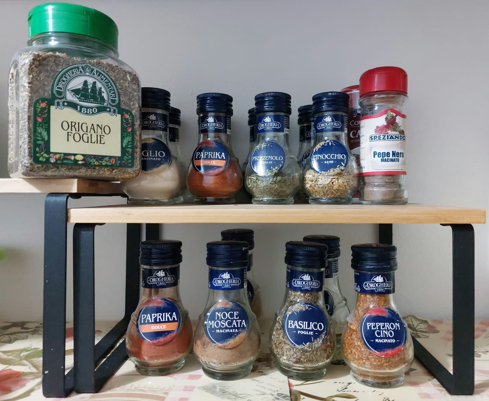 A kitchen spice rack with sweet paprika, nutmeg, garlic, black pepper, and other seasonings.
