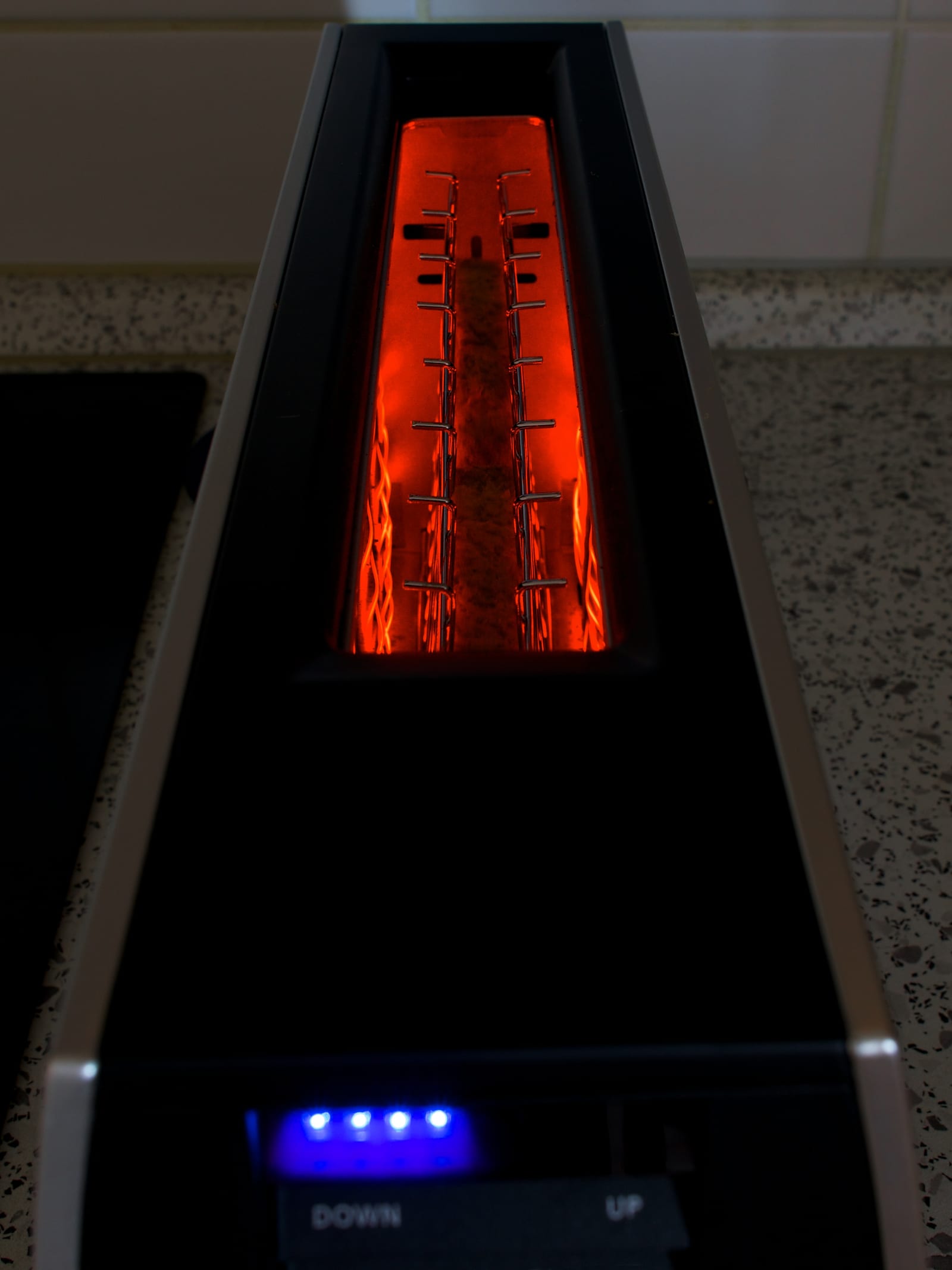 Top-down view into an operating pop-up toaster with its heating elements glowing orange-red.